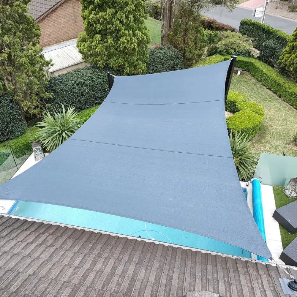 Triangular Sail Shades installed over a backyard seating area